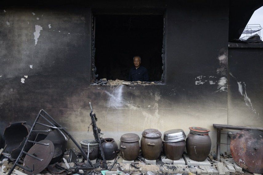 Kim Seung-weon permanece entre los restos quemados de su casa, dos días después de que un incendio forestal arrasara su aldea, en Andong, el 27 de marzo de 2025. La lluvia caída durante la noche ayudó a sofocar algunos de los peores incendios forestales de la historia de Corea del Sur, informaron las autoridades el 28 de marzo, mientras que la cifra de muertos por los incendios sin precedentes, que duraron casi una semana, ascendió a 28.&nbsp;&nbsp;