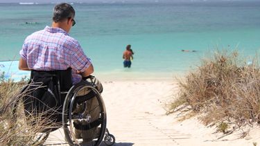 Un hombre en silla de rueda disfruta de la playa
