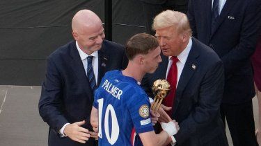El centrocampista inglés del Chelsea, Cole Palmer (centro), recibe el Balón de Oro de manos del presidente de la FIFA, Gianni Infantino (izq.), y del presidente de los Estados Unidos, Donald Trump (der.), durante la ceremonia de entrega de premios a los campeones de la Copa Mundial de Clubes de la FIFA 2025.