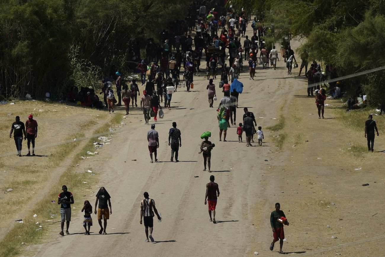 Migrantes haitianos caminan por un camino de tierra después de ingresar a Estados Unidos desde México, el viernes 17 de septiembre de 2021, en Del Rio, Texas. Migrantes haitianos caminan por un camino de tierra después de ingresar a Estados Unidos desde México, el viernes 17 de septiembre de 2021, en Del Rio, Texas.