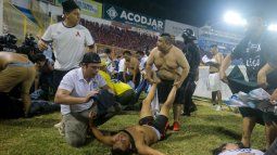 Aficionados al fútbol atienden en la cancha a los heridos por una estampida humana en el estadio Cuscatlán de San Salvador, el sábado 20 de mayo de 2023&nbsp;
