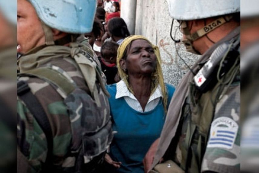 Una mujer mira con rostro desafiante a uno de los soldados del ejército de Uruguay emplazados en Haití como fuerza de paz de la ONU (CORTESÍA)