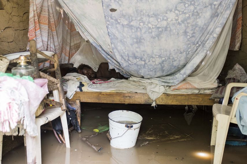 Un hombre descansa en su cama mientras su vivienda permanece inundada tras el paso del huracán Irma.