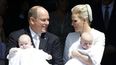El príncipe Alberto de Mónaco y su esposa Charlene posan en la catedral después del bautizo de sus gemelos Jaime y Gabriela el 10 de mayo de 2015. (AFP)