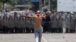 Un opositor venezolano se enfrenta a efectivos de la Guardia Nacional del régimen de Nicolás Maduro que bloqueaban el paso de la ayuda humanitaria por el Puente Internacional Simón Bolívar, en Cúcuta, Colombia.