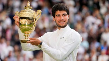 Carlos Alcaraz alza el trofeo de campeón de Wimbledon tras derrotar a Novak Djokovic en la final, el domingo 16 de julio de 2023, en Londres.