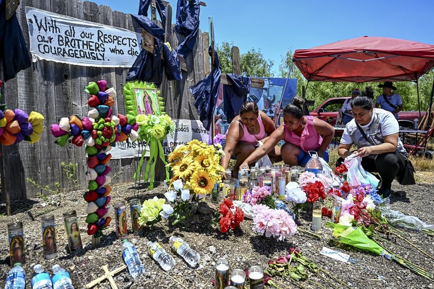 La gente coloca flores y velas en un monumento improvisado donde se descubrió un camión con remolque con migrantes adentro, en las afueras de San Antonio, Texas, el 29 de junio de 2022.&nbsp;