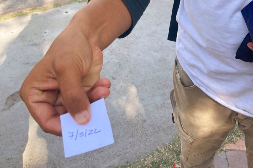 Un migrante muestra un papel con la fecha en que fue citado por la Casa del Migrante de Piedras Negras (México) para iniciar el proceso con miras a un posible ingreso a EEUU. La entrevista fue cancelada posteriormente porque el servicio estaba desbordado.