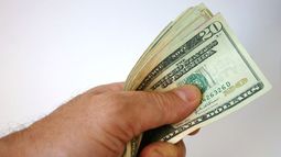 Una persona sostiene billetes de 20 dólares.