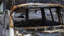Un hombre camina por una calle con varios cadáveres en el suelo en una calle de Bucha, al noroeste de Kiev, mientras Ucrania dice que las fuerzas rusas están haciendo una retirada rápida de las áreas del norte alrededor de Kiev y la ciudad de Chernigiv, el 2 de abril de 2022.&nbsp;&nbsp;