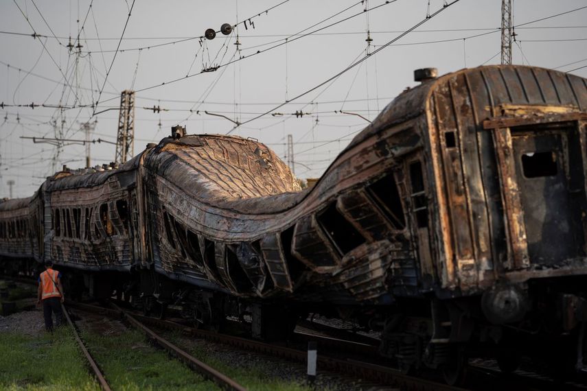 Un trabajador ferroviario camina al lado de un tren severamente dañado tras un ataque ruso a una estación de trenes durante el Día de la Independencia de Ucrania, en la aldea de Chaplyne, Ucrania, el jueves 25 de agosto de 2022.&nbsp;