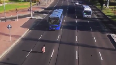 hombre arriesga su vida al cruzar una transitada calle