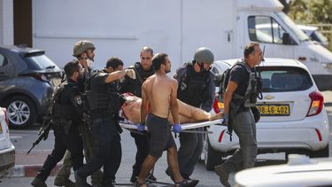 Las fuerzas de seguridad israelíes evacuan a una mujer herida de un lugar alcanzado por un cohete disparado desde la Franja de Gaza, en Ashkelon, sur de Israel, el sábado 7 de octubre de 2023.&nbsp;