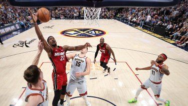 Jimmy Butler (22) del Heat de Miami Christian Braun de los Nuggets de Denver pugnan por un balón en el quinto de las Finales de la NBA, el lunes 12 de junio de 2023, en Denver.