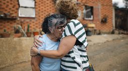 Vecinos de Castrocalbón junto a una vivienda que ha sido destruida por los incendios, a 20 de agosto de 2025, en Castrocalbón, León, Castilla y León (España).&nbsp;