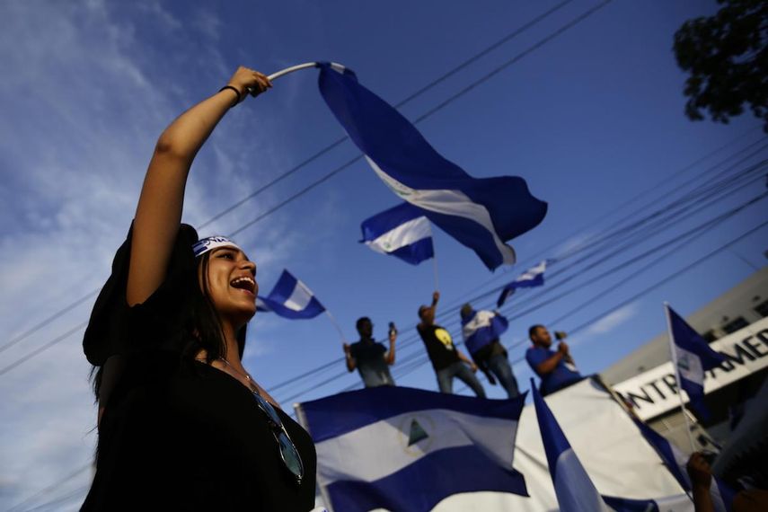 Una joven ondea una bandera nacional durante una protesta en la ciudad de Managua.