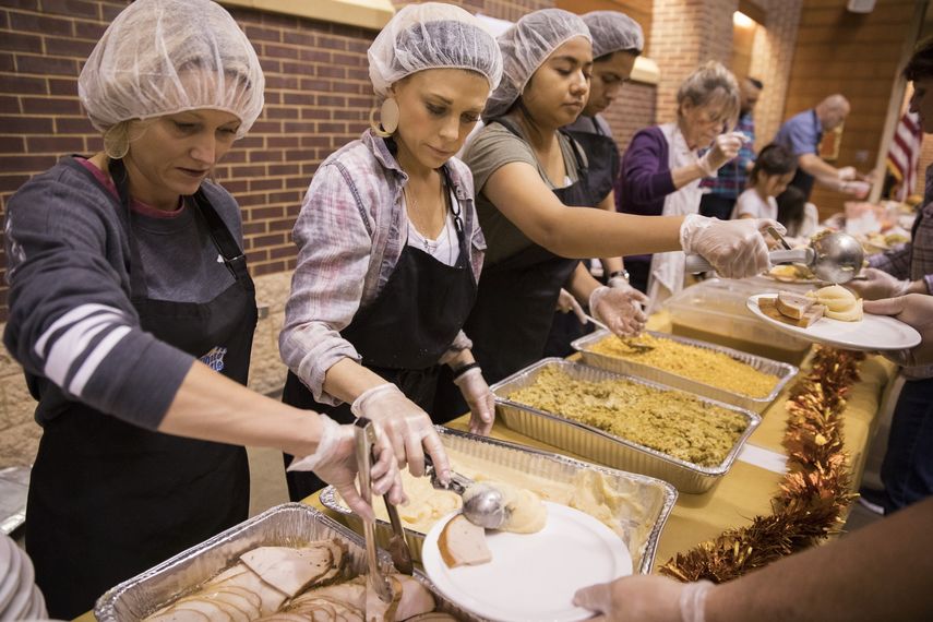 Voluntarios reparten comida a necesitados.