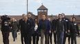 Arnold Schwarzenegger y Simon Bergson, presidente de Auschwitz Jewish Center Foundation, 3ero de izquierda a derecha, visitan el antiguo campo de exterminio nazi Auschwitz-Birkenau en Oswiecim, Polonia, el miércoles 28 de septiembre de 2022.