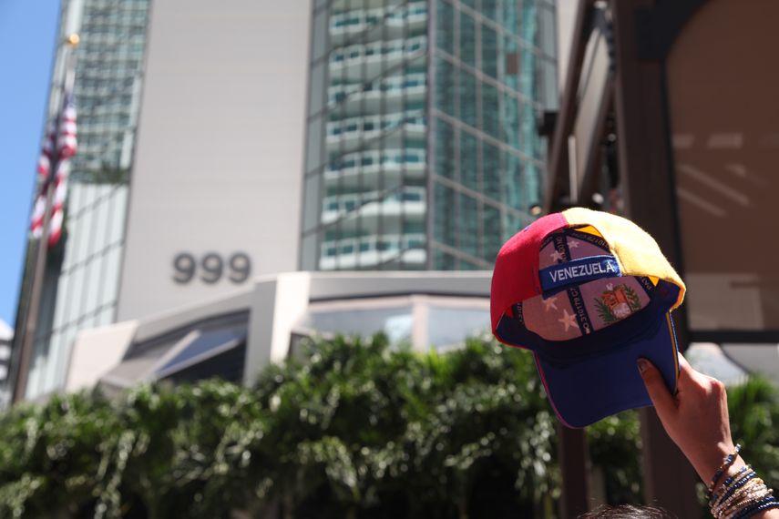 Uno de los manifestantes alza una gorra con la bandera de Venezuela.&nbsp;