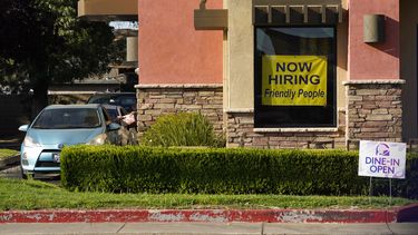 Un anuncio de un puesto vacante es exhibido en la ventana de un restaurante.