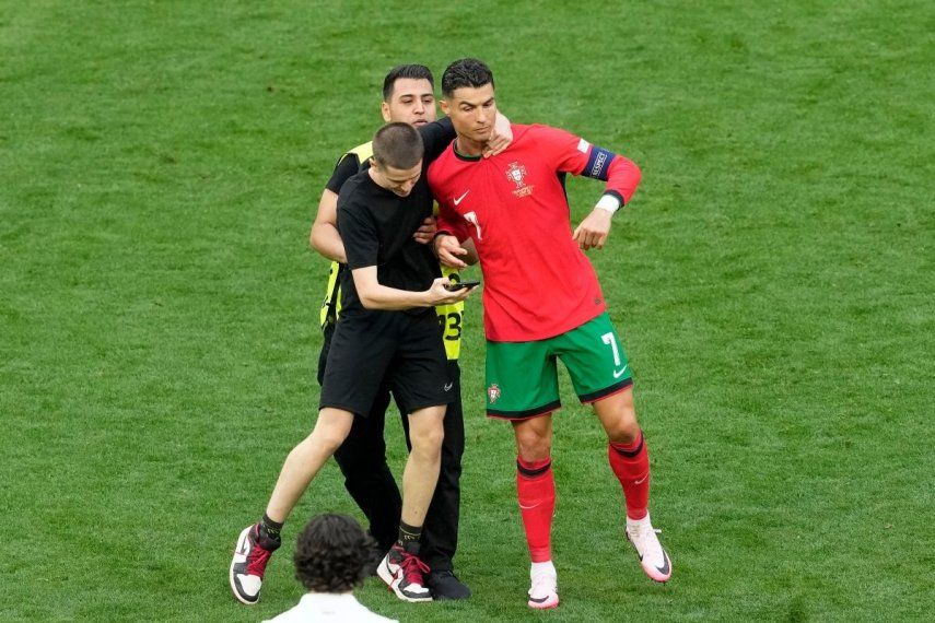 Un aficionado toma del cuello a Cristiano Ronaldo durante el duelo de Portugal en el Grupo F ante Turquía en la Eurocopa, el sábado 22 de junio del 2024.&nbsp;