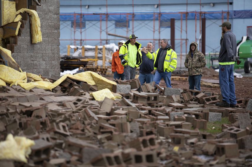 Empleados de Stewart Richey Electrical y otros trabajadores despejan escombros en Thornton Furniture el sábado 1 de enero de 2022, en Bowling Green, Kentucky, tras otro aviso de posible tornado.&nbsp;