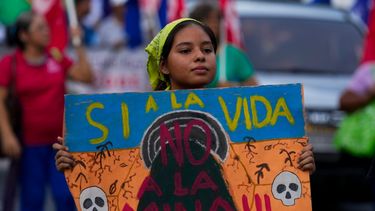 Una manifestante sostiene una pancarta durante una protesta en las proximidades de la Asamblea Nacional de Panamá en contra del contrato firmado por el gobierno y una minera de Canadá.
