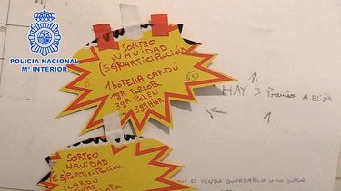 Esta imagen de folleto tomada el 2 de diciembre de 2021 y publicada por la Policía Nacional española el 21 de diciembre de 2021 muestra notas en un tablero que promociona el sorteo de una Cesta de Navidad que contenía cocaína, hierba y hachís, entre otras cosas, que se encontraron durante una redada de drogas en Murcia.