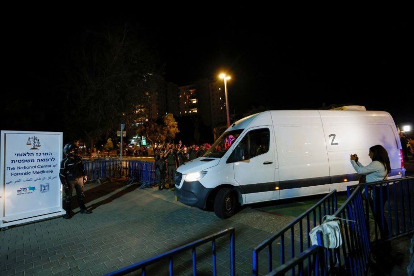 Soldados israelíes saludan mientras vehículos que transportan los cuerpos de cuatro rehenes entregados tras un acuerdo de alto el fuego e intercambio de prisioneros entre Israel y facciones palestinas en Gaza, llegan al Centro Nacional de Medicina Forense en Tel Aviv el 13 de octubre de 2025.