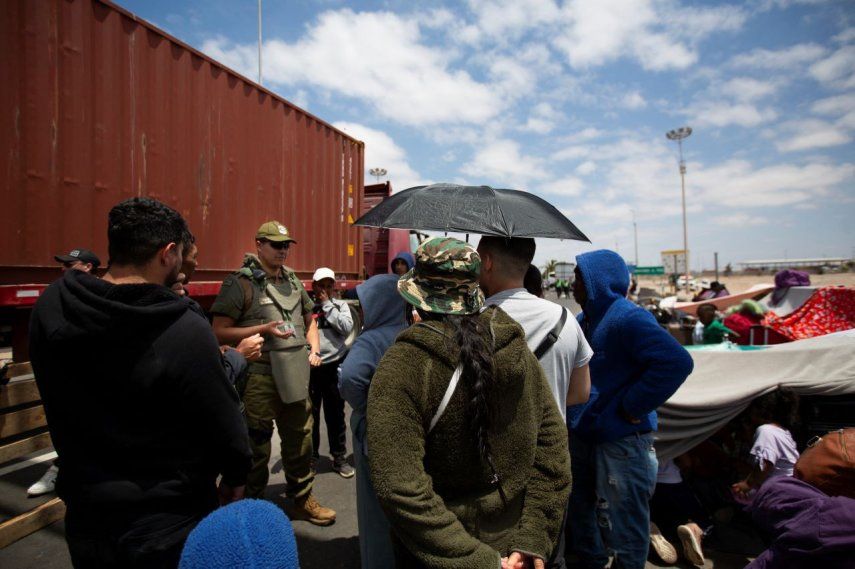 Inmigrantes de Venezuela son abordados por un carabinero cerca del paso fronterizo de Cachalluta con Perú, a unos 25 km al norte de Arica, Chile, el 28 de noviembre de 2025.