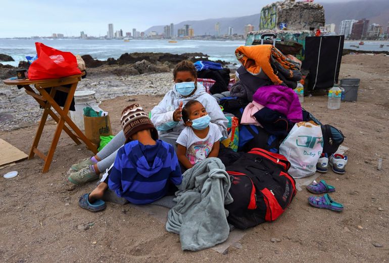 Una familia de migrantes venezolanos instaló un campamento a lo largo de una playa después de que ellos y otros migrantes fueran desalojados por la policía de la Plaza Brasil donde vivían en tiendas de campaña, en Iquique, Chile.