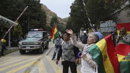 Varias personas protestan en la entrada que conduce a la embajada mexicana para asegurarse de que nueve exfuncionarios del gobierno del depuesto presidente boliviano Evo Morales, que se han refugiado en el interior, no salgan del pa&iacute;s, en La Paz, Bolivia, el lunes 30 de diciembre de 2019.&nbsp;