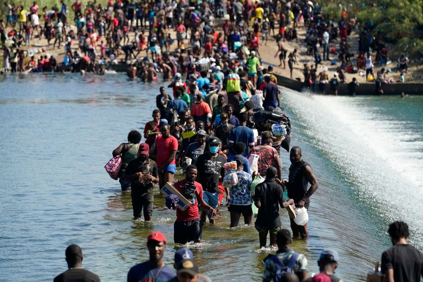 Migrantes usan una represa para cruzar entre México y Estados Unidos el viernes 17 de septiembre de 2021 en Del Rio, Texas.