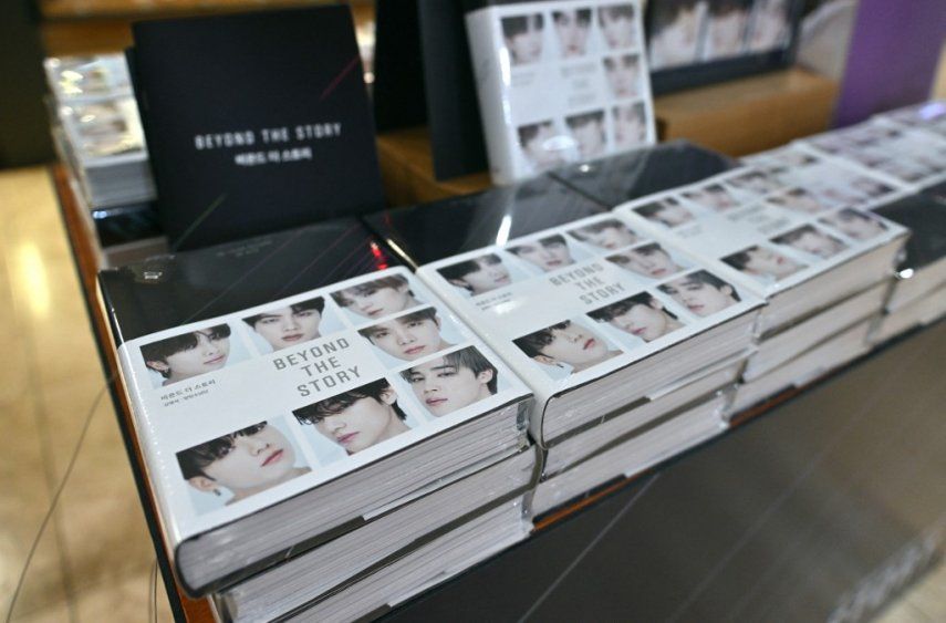 Una mujer mira las copias de las memorias de BTS tituladas Beyond the Story: 10-Year Record of BTS (Más allá de la historia: récord de 10 años de BTS) que se exhiben como parte de un lanzamiento mundial en una librería en Seúl el 9 de julio de 2023.