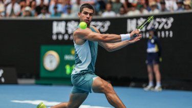 El español Carlos Alcaraz devuelve una pelota al japonés Yoshihito Nishioka durante su partido individual masculino en el cuarto día del torneo de tenis Abierto de Australia en Melbourne, el 15 de enero de 2025. 