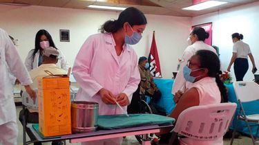 Una enfermera habla con una mujer que está a punto de ser inoculada con la vacuna AstraZeneca COVID-19 en el hospital Bertha Calderón en Managua, Nicaragua, el jueves 8 de abril de 2021. El FMI dijo el jueves 15 de abril que la persistencia de la crisis sanitaria desencadenada por la pandemia de coronavirus ensombrece las perspectivas económicas de América Latina en el corto plazo.