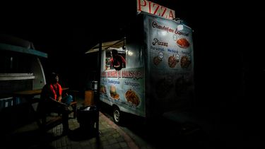 Un vendedor ambulante utiliza una bombilla alimentada por un generador en medio de apagones en Manta, Ecuador.&nbsp;