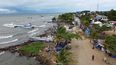 Migrantes se reúnen en Necoclí, Colombia, un punto de parada para los migrantes que toman embarcaciones hacia Acandí, una localidad que conduce a la selva del Tapón del Darién.