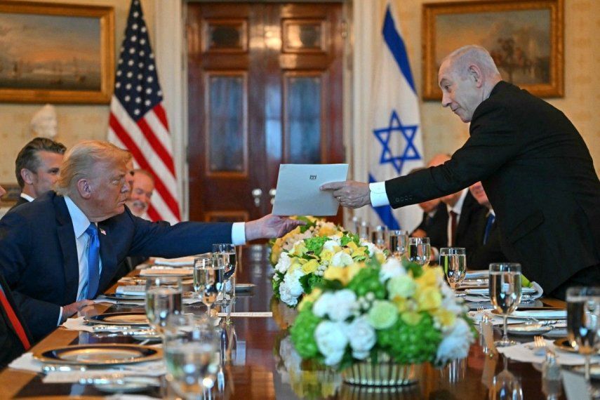 El primer ministro israelí, Benjamin Netanyahu (der.), entrega una carta al presidente estadounidense, Donald Trump, durante su reunión en la Sala Azul de la Casa Blanca en Washington, D.C., el 7 de julio de 2025.&nbsp;