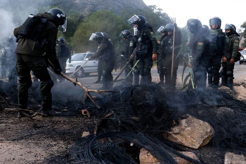 Agentes de la policía boliviana despejan un bloqueo en la carretera entre Cochabamba y La Paz durante una protesta de movimientos sociales que exigían la renuncia del presidente Rodrigo Paz cerca de Parotani, Bolivia, el 21 de mayo de 2026.