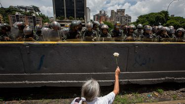 Una señora le entrega una flor a los Guardias Nacionales que custodiban lña marcha el paso 19 de abril.&nbsp;
