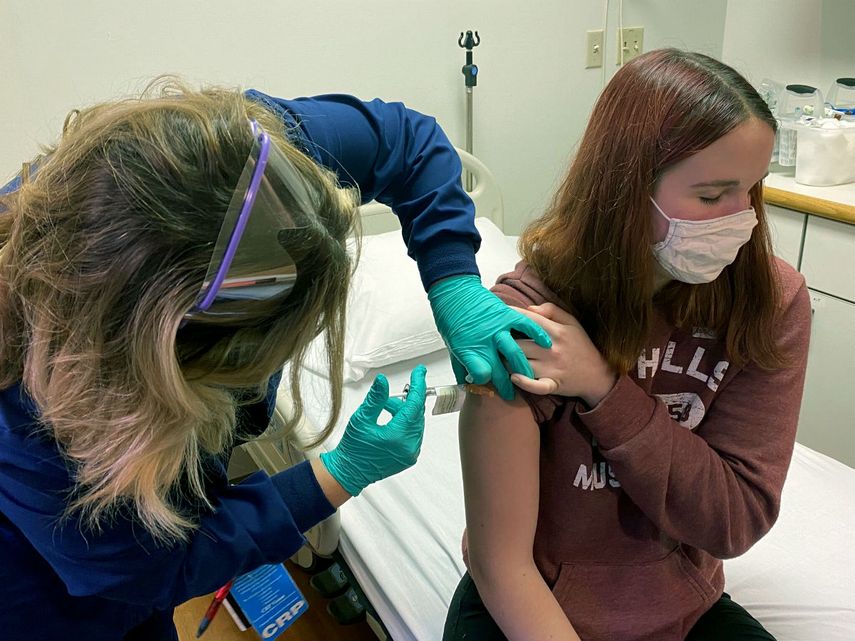 En esta fotografía proporcionada por el Centro Médico del Hospital Infantil de Cincinnati, Tammy Lewis-McCauley, coordinadora de investigación clínica, le aplica una inyección a Katelyn Evans el miércoles 21 de octubre de 2020 como parte del ensayo clínico del hospital de una vacuna contra COVID-19 en fase de prueba desarrollada por Pfizer.