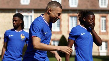 El atacante Kylian Mbappé (centro), de Francia, sonríe durante una sesión de fotos de la selección gala, el 18 de marzo de 2025.&nbsp;