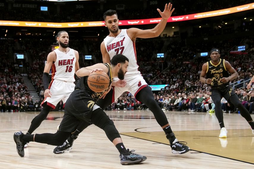 El base Fred VanVleet, de los Raptors de Toronto, trata de abrirse paso ante el pívot Omer Yurtseven (77), del Heat de Miami, en juego de NBA del domingo 3 de abril de 2022, en Toronto