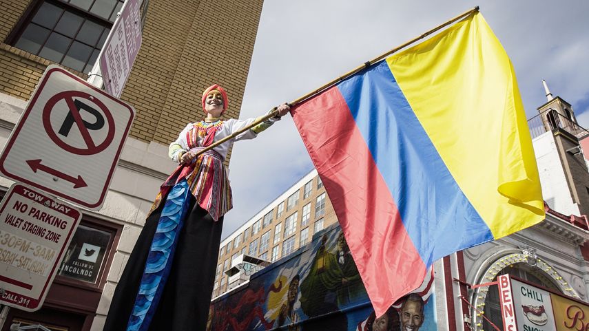 Una mujer enarbola la bandera colombiana.