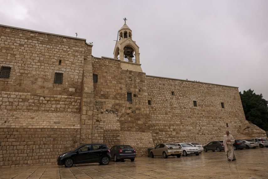 Un peregrino camina frente a la Iglesia de la Natividad en la ciudad ocupada de Belén, en Cisjordania, el 13 de diciembre de 2023, menos de dos semanas antes de Navidad, en medio de continuas batallas entre Israel y Hamás, en Gaza.