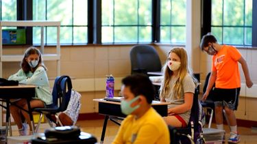 Estudiantes de quinto grado portan mascarillas en espera de su maestro en un aula de la Escuela Primaria.&nbsp;
