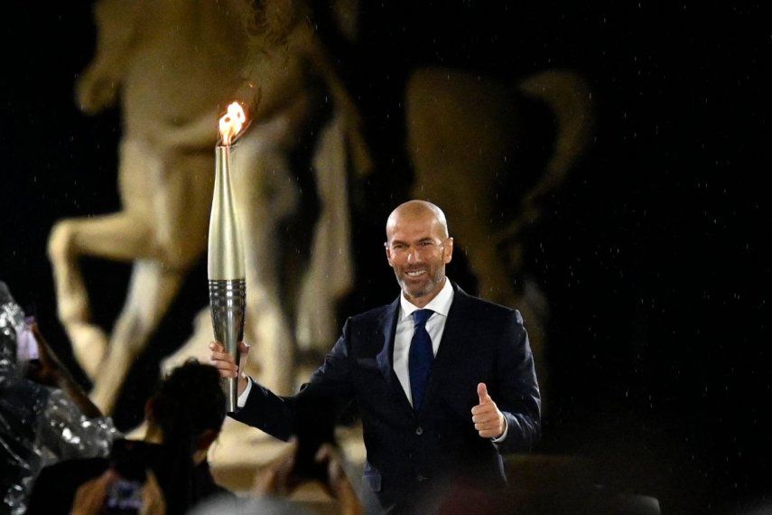 El exjugador de fútbol francés, Zinedine Zidane, sostiene la antorcha olímpica durante la ceremonia de apertura de los Juegos Olímpicos de París, el 26 de julio de 2024.