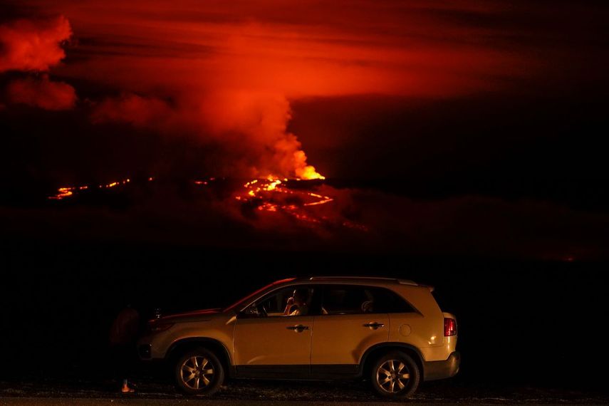 Un hombre conversa por teléfono desde su auto a lo largo de Saddle Road, la principal carretera que une las costas este y oeste de la Isla Grande de Hawai, al tiempo que el volcán Mauna Loa hace erupción el miércoles 30 de noviembre de 2022, cerca de Hilo, Hawai.&nbsp;