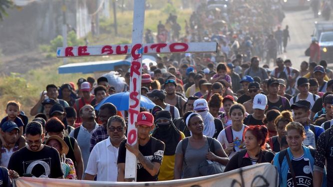 Migrantes que caminan por la carretera llevan una cruz que dice en español Cristo Resucitado durante la Semana Santa mientras avanzan por Tapachula en el estado mexicano de Chiapas, el lunes 25 de marzo de 2024.